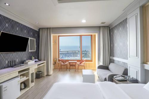a hotel room with a bed and a living room at Boryeong BonGaya Hotel in Boryeong