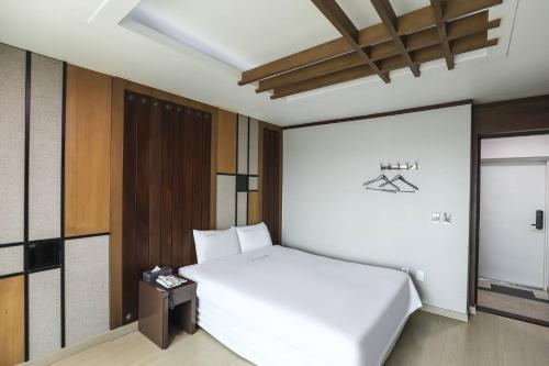 a bedroom with a white bed in a room at Boryeong BonGaya Hotel in Boryeong