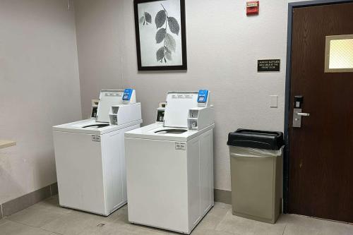 three washing machines in a room next to a door at Country Inn & Suites by Radisson, Austin North Pflugerville , TX in Round Rock