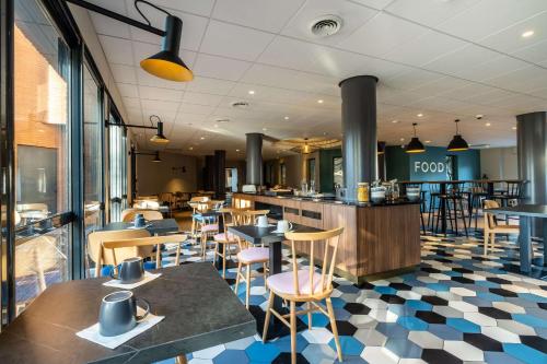 a restaurant with a checkered floor and tables and chairs at Clarion Aparthotel Toulouse Blagnac Airport in Blagnac
