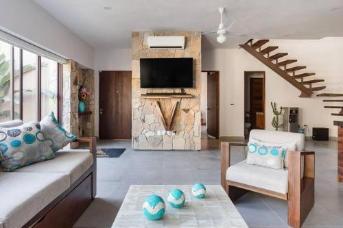 a living room with a couch and a tv at Villa Vargas Sayulita in Sayulita