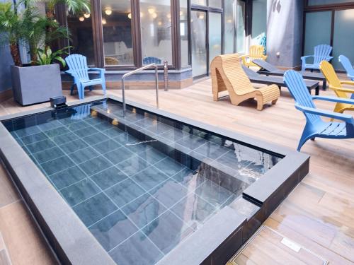 a pool in a building with chairs and tables at Miyazaki Daiichi Hotel in Miyazaki