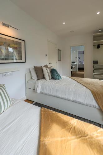 a white bedroom with a bed and a couch at Muramar Beach House in Meirás
