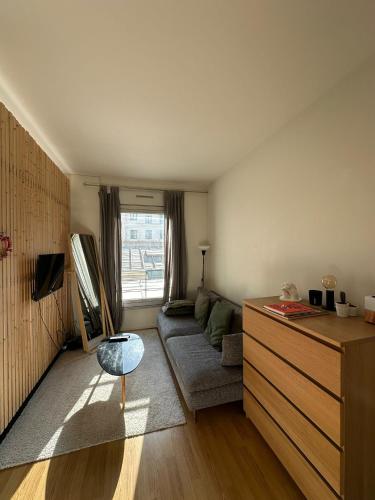 un salon avec un canapé et une table dans l'établissement Studio cosy coeur paris - quartier Opéra, à Paris