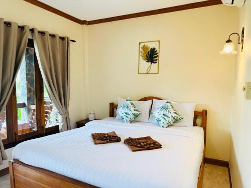a bedroom with a bed with two towels on it at Family House Resort, Haad Rin in Haad Rin