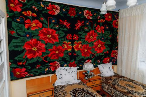 a bedroom with a large floral mural on the wall at Casa familiei Iarmurati in Pohrebea