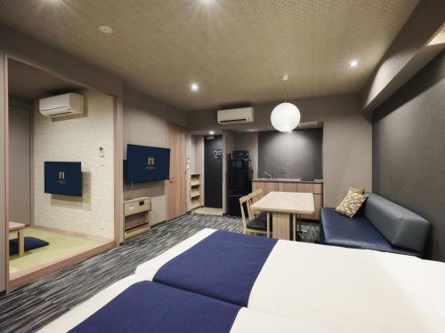 ein Schlafzimmer mit einem Bett, einem Schreibtisch und einem Tisch in der Unterkunft MONday Apart Premium AKIHABARA in Tokio