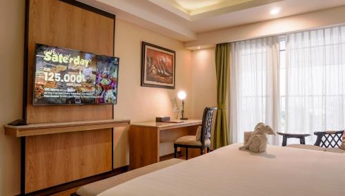 a hotel room with a bed and a tv at Grand Sunshine Resort & Convention in Bandung