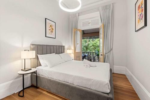 a bedroom with a large white bed and a window at Elegant 6-Bed Home with Harbour Views in Sydney
