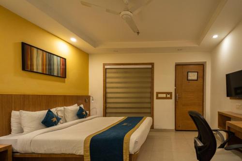 a hotel room with a bed and a television at Sparrow Hotel Managed by Siara Sariska Alwar in Alwar