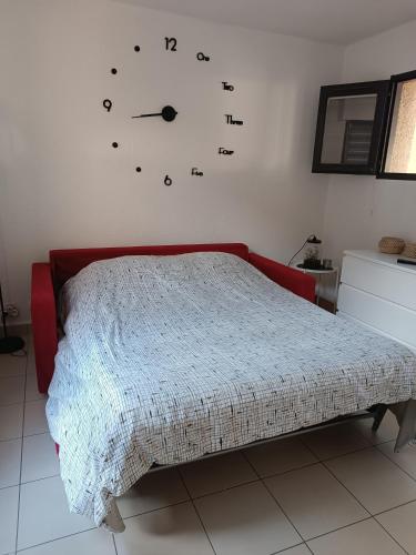 - une chambre dotée d'un lit avec une horloge murale dans l'établissement studio rénové dans résidence de vacances avec grande piscine chauffée, parking et terrasse, au Cap d'Agde