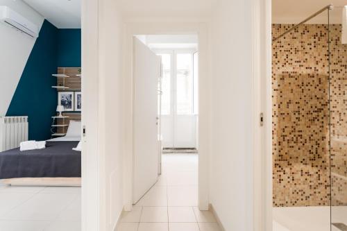 a bedroom with white walls and a glass door leading to a bed at Casa Papaccio Apartment & Spa By Dimorra in Naples
