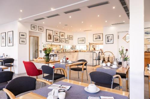 a restaurant with tables and chairs and a kitchen at Inselhotel Rügen in Göhren
