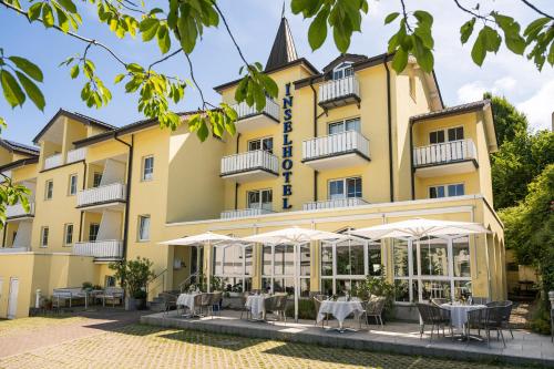 a hotel with tables and chairs in front of a building at Inselhotel Rügen in Göhren