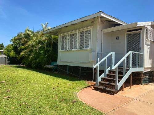 a house with a staircase in front of a yard at 5 Learmonth Street in Exmouth