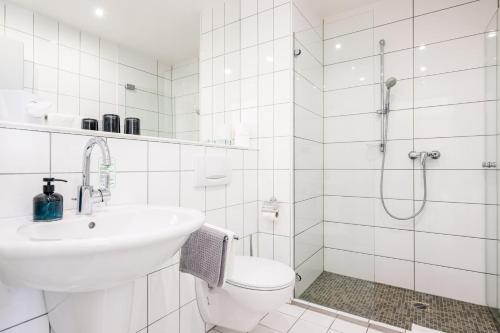 a bathroom with a sink and a toilet and a shower at Inselhotel Rügen in Göhren