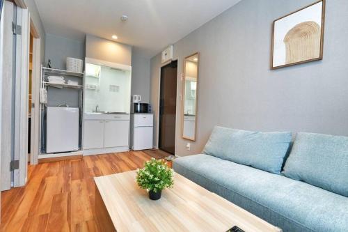 a living room with a blue couch and a table at ZJ202 Hanama202 The Skytree Residence A Newly Home by Tokyo Iconic Landmarks in Tokyo