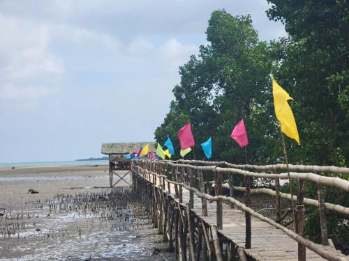 a row of flags on a wooden fence on a beach at Bamboo House in Roxas