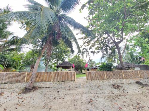 a palm tree standing next to a wooden fence at Bamboo House in Roxas