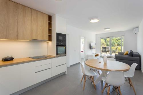 a kitchen and dining room with a table and chairs at Apartments at Villa Frida in Premantura