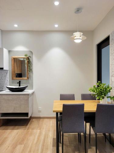 a dining room with a table and a sink at Capsule Onsen Landmark in HÆ°ng YÃªn