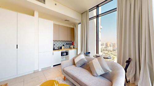 a living room with a couch and a large window at The Community Jumeirah Village in Dubai