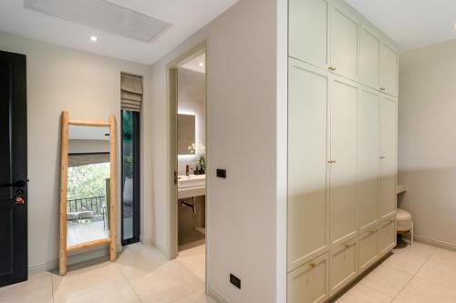 a kitchen with white cabinets and a bathroom with a sink at Villa Divano - by Sublime Samui Villas in Choeng Mon Beach
