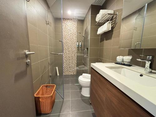 a bathroom with a toilet and a sink and a shower at 1001 Nights Hotel, Trademark Collection by Wyndham in Genting Highlands