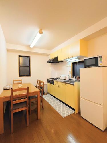 a kitchen with a table and a refrigerator at honeys guest house elevator , wash machine, huge closet space, private bathroom, walk to skytree in 10 minutes in Tokyo