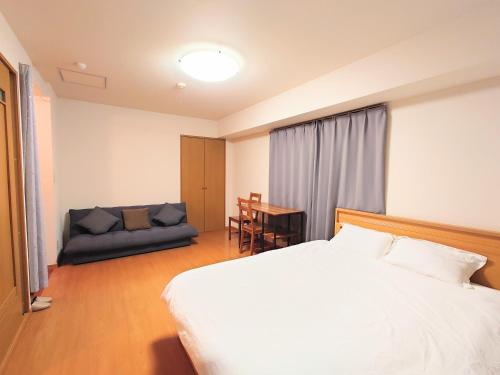 a hotel room with a bed and a couch at honeys guest house elevator , wash machine, huge closet space, private bathroom, walk to skytree in 10 minutes in Tokyo