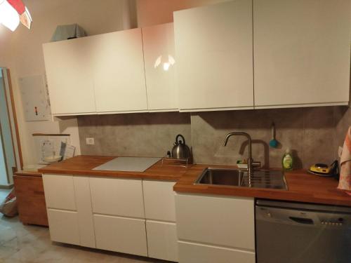 a kitchen with white cabinets and a sink at dalla nonna Paola in Robbiate