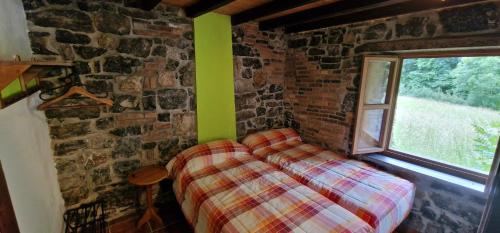 a bedroom with a bed in a brick wall at Redes - El Descanso - AR-484-AS in Caso