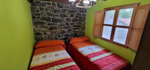 two beds in a green room with a window at Redes - El Descanso - AR-484-AS in Caso