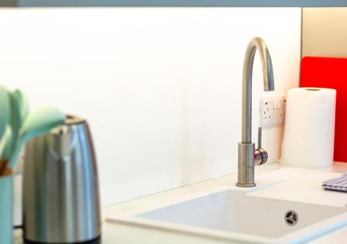 a kitchen sink with a faucet on a counter at Bright & Airy 2BD - 10 mins walk to Chelt Centre! in Cheltenham