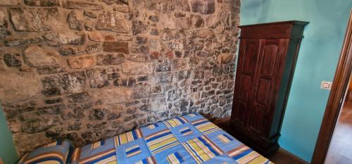 a bed in a room with a stone wall at Redes - El Descanso - AR-484-AS in Caso