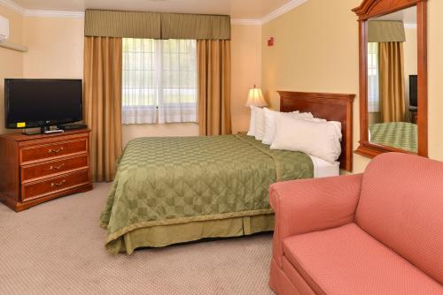 a hotel room with a bed and a tv and a couch at Fremont Inn in Lakeview