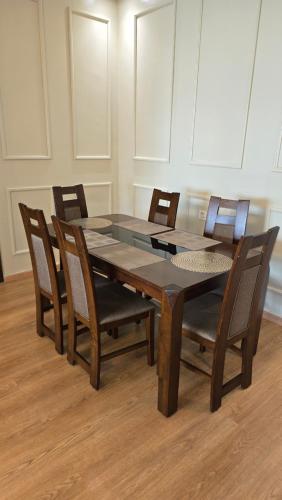 a dining room table and chairs in a room at Le doux refuge - à 7 mn de la plage à pieds in Temara