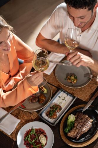 a group of people sitting at a table with wine glasses at Nevo by Isrotel Collection in Ein Bokek