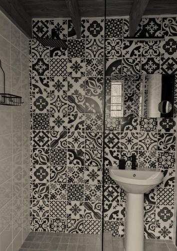 a bathroom with a sink and a tile wall at Injabulo in Marloth Park