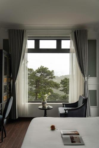 a bedroom with a bed and a large window at The Gate Boutique Hotel Đà Lạt in Da Lat