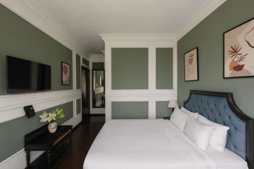 a bedroom with a large bed and a tv at The Gate Boutique Hotel Đà Lạt in Da Lat