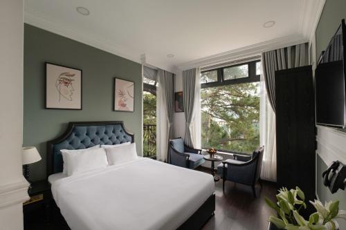 a bedroom with a white bed and a window at The Gate Boutique Hotel Đà Lạt in Da Lat