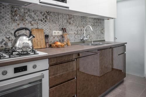 トビリシにあるGuest Home in the Heart of old Tbilisi centerのキッチン(コンロ、カウンターのティーポット付)