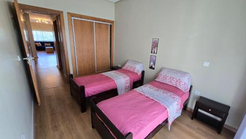 two beds in a room with pink sheets at Le doux refuge - à 7 mn de la plage à pieds in Temara