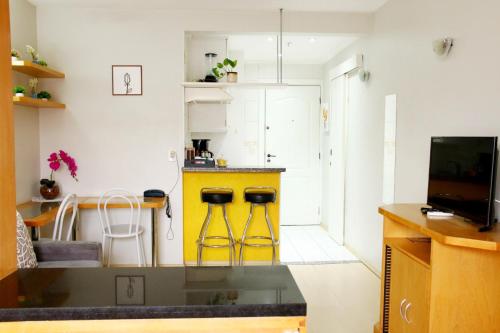 a kitchen with a yellow counter and stools at Flats em frente ao Allianz Parque - HOTEL EM PERDIZES in Sao Paulo