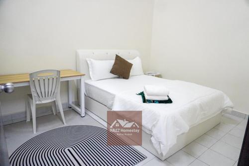 a bedroom with a bed and a desk and a chair at HAZZ Homestay Kulim IV in Kulim