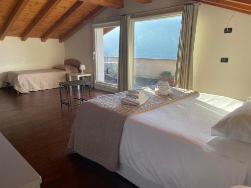 a bedroom with a large bed and a large window at La Bella Ossuccio in Ossuccio