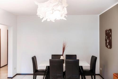 a dining room with a table with chairs and a chandelier at City Escape by Quokka 360 - Close to Lugano Center in Viganello