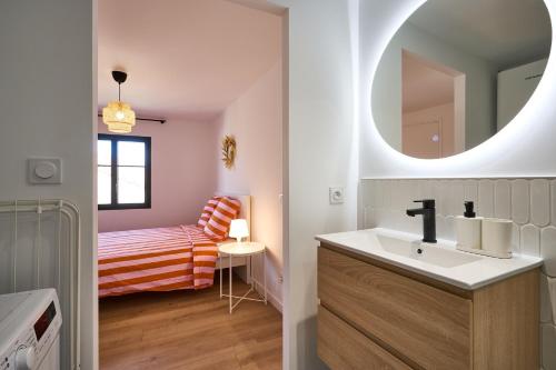 une salle de bain avec un lavabo et un miroir dans l'établissement La Villa Orange, à Carcassonne