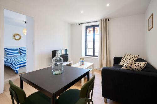 un salon avec une table et des chaises et une chambre dans l'établissement La Villa Orange, à Carcassonne